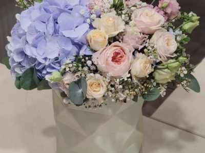 Композиция в коробочке с голубой гортензией, пионовидными и кустовыми розами, эустомой, твидией