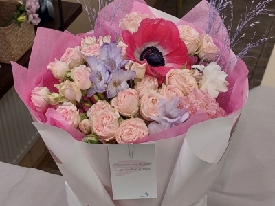 Букет с пионовидными розами, анемонами, фрезией и паникумом.